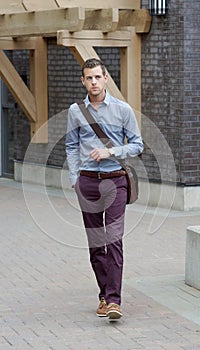 Handsome Young Adult Male Walking With A Messenger Bag