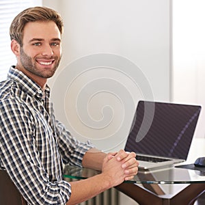 Handsome young adult man smiling at camera over his shoulder