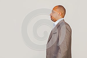 Handsome young African American businessman in a jacket, standing in profile, looking to the side, posing for a photo on