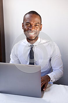 Handsome young african american businessman working with laptop