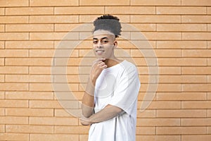 A handsome young African-American man, holding hand to his face, wearing a white T shirt