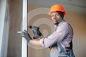 handsome young african american man installing bay window in new house construction site