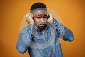 Handsome young african american man listening to music with blue headphones