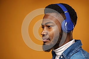 Handsome young african american man listening to music with blue headphones