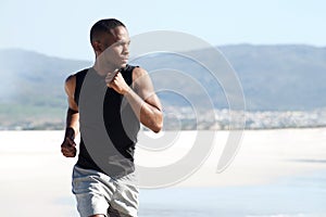 Handsome young african american man running on the beach