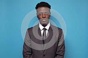 Handsome young African American serious businessman wearing a black suit and tie