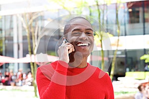 Handsome young african man laughing with cell phone