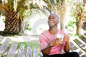 Handsome young african man relaxing outdoors with a cup of coffee