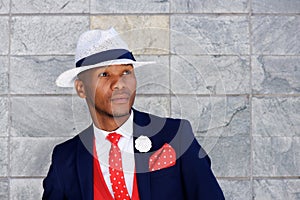 Handsome young african man in suit and hat looking away