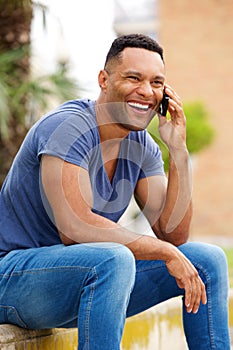 Handsome young african man talking on smart phone and smiling