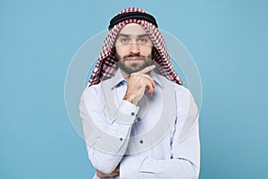 Handsome young arabian muslim man in keffiyeh kafiya ring igal agal casual clothes isolated on pastel blue background