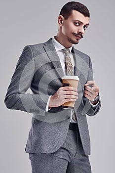 Handsome young arabic businessman with mustache in fashion gray suit