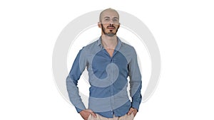 Handsome young arabic man wearing a casual outfit walking, putting his both hands in his pockets on white background.