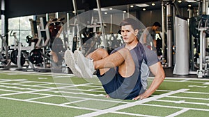 Handsome young Asian guy lying on exercise doing sit-ups fat burning workout in fitness class. Athlete with six pack, Sportsman