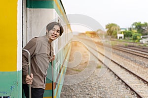 Handsome Young Asian man hand to say hello or goodbye to friend on train, Waving Goodbye