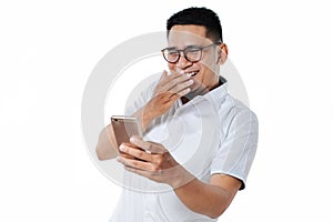 Handsome Young Asian man wearing eyesglasses watching funny video on mobile phone
