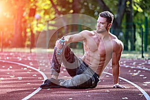 Handsome young athlete working out on a running track