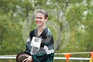 Handsome young Australian man sporting competitor caught in rain