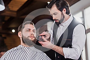 handsome young barber shaving man