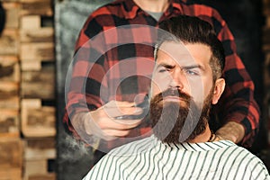 Handsome young bearded guy in barber shop. Getting perfect shape. Barbershop. Beard grooming. Bearded stylish hipster