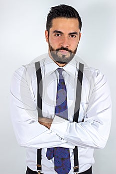 Handsome young bearded man in formal wear with crossed arms.