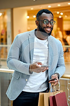 handsome young bearded man holding smartphone, credit card