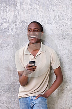 Handsome young black guy laughing with mobile phone