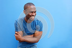 Handsome young black man laughing with arms crossed