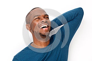 Handsome young black man laughing with hand behind head by isolated white background