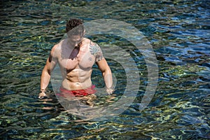 Handsome young bodybuilder and swimmer in the sea