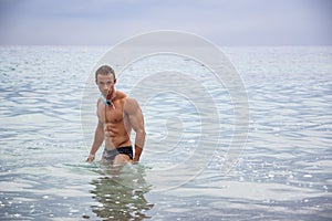 Handsome young bodybuilder and swimmer in the sea
