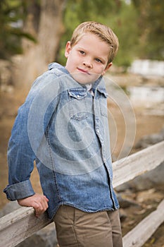 Handsome Young Boy Against Fence in Park