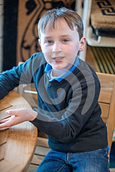 Handsome young boy sits in chair all dressed up for Easter holidays
