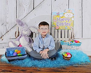 Handsome young boy sitting in Easter scene