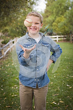 Handsome Young Boy Tossing Up Baseball in the Park