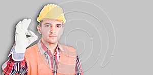 Handsome young builder showing ok sign at work