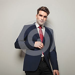 Handsome young business man closing his jacket