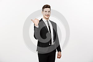 Handsome young business man happy smile point finger to empty copy space, businessman showing pointing side, concept of