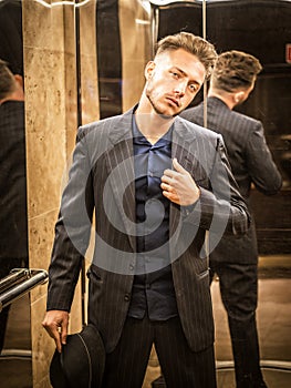 Handsome young man inside an elevator looking at camera