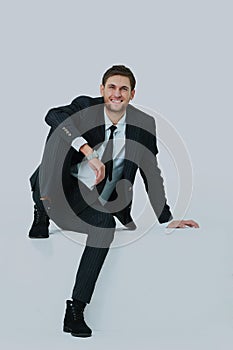 Handsome young business man sitting on a white modern chair.