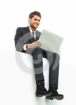 Handsome young business man sitting on a white modern chair