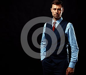 Handsome young business man standing on black