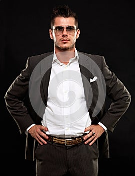 Handsome young business man standing on black