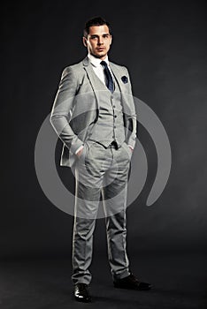 Handsome young business man standing on black