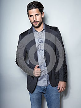 Handsome young business man in suit on grey background