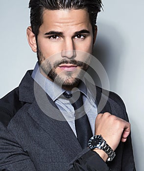 Handsome young business man in suit on grey background