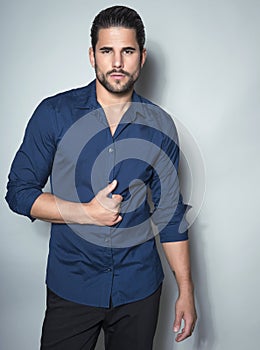 Handsome young business man in suit on grey background