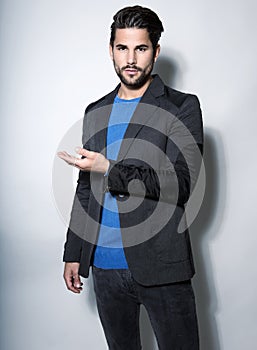 Handsome young business man in suit on grey background