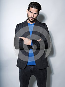 Handsome young business man in suit on grey background