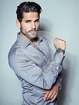 Handsome young business man in suit on grey background